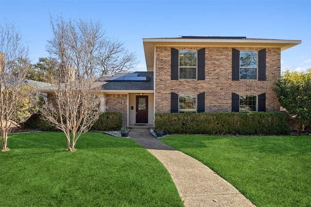 view of front facade featuring a front yard and solar panels