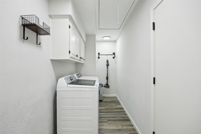 laundry room with cabinets, washer and dryer, and dark hardwood / wood-style flooring