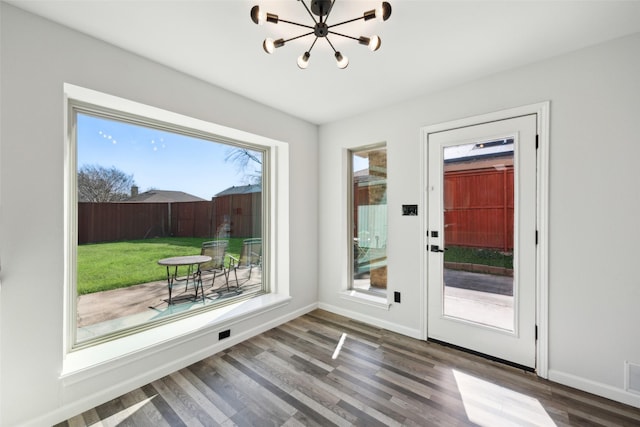 doorway to outside with hardwood / wood-style flooring and a chandelier