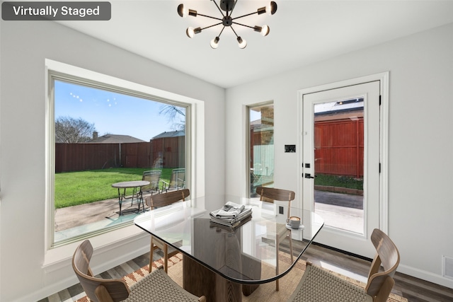 doorway to outside with an inviting chandelier and hardwood / wood-style floors