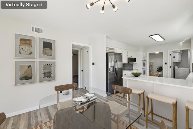 dining area with wood-type flooring and a chandelier