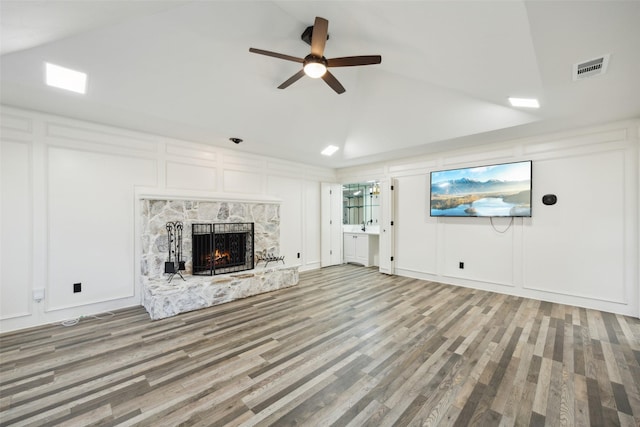 unfurnished living room with a premium fireplace, vaulted ceiling, hardwood / wood-style floors, and ceiling fan