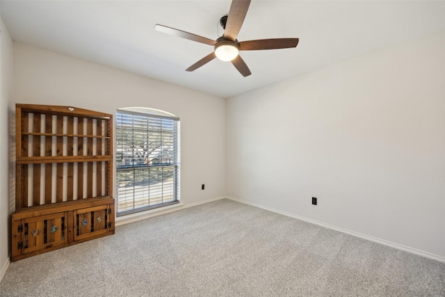 carpeted spare room featuring ceiling fan