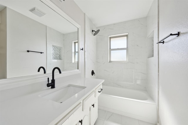 bathroom with tiled shower / bath and vanity