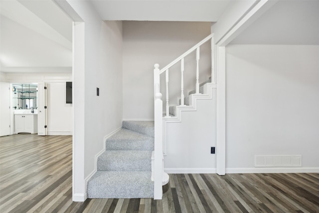 staircase with hardwood / wood-style floors