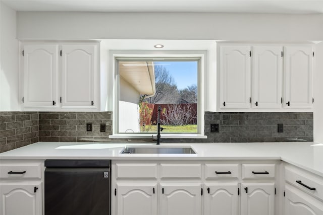 kitchen featuring tasteful backsplash, sink, black dishwasher, and white cabinets