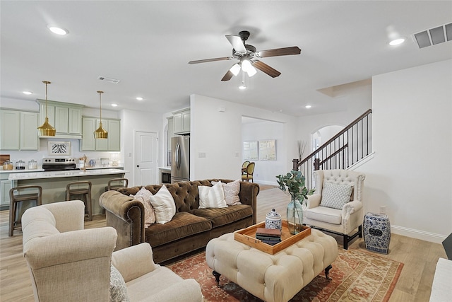 living room featuring light hardwood / wood-style floors and ceiling fan