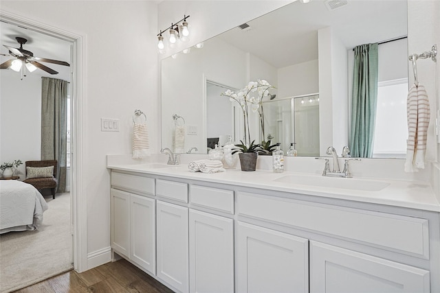 bathroom with a shower with door, wood-type flooring, vanity, and ceiling fan