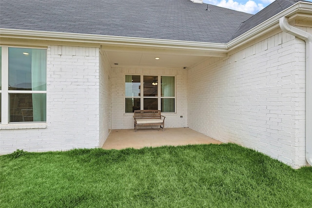 entrance to property with a patio and a yard