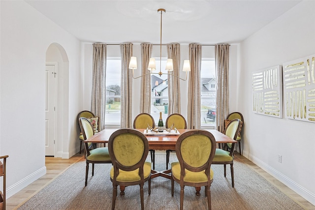 dining area featuring light hardwood / wood-style flooring and a chandelier