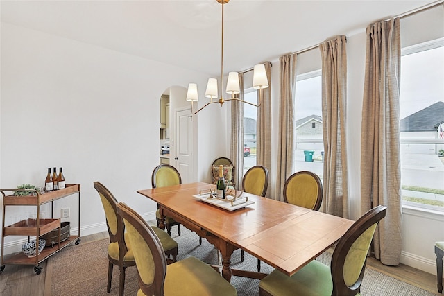 dining space featuring light hardwood / wood-style flooring and a notable chandelier