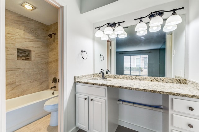 full bathroom with tiled shower / bath, vanity, and toilet