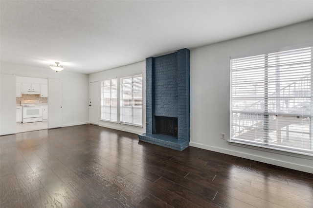 unfurnished living room with dark wood-type flooring and a fireplace