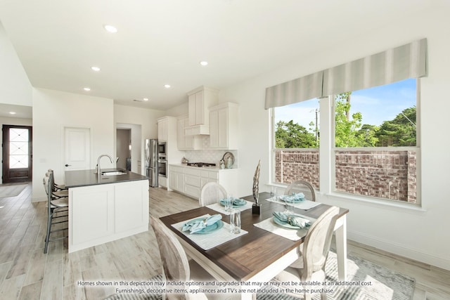 dining space with sink and light hardwood / wood-style flooring