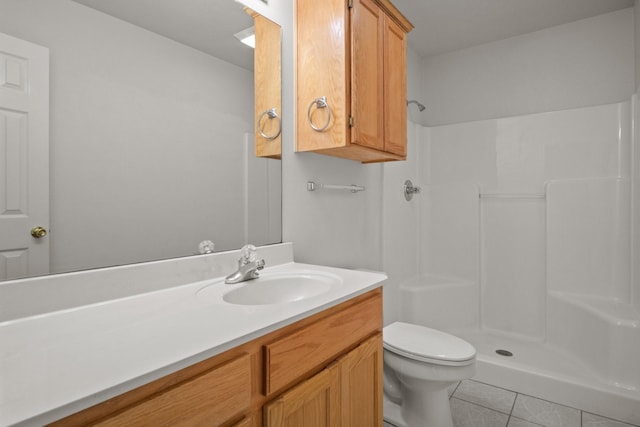 bathroom with a shower, vanity, tile patterned floors, and toilet