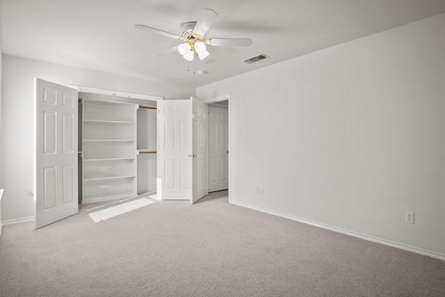 unfurnished bedroom featuring light carpet, a closet, and ceiling fan