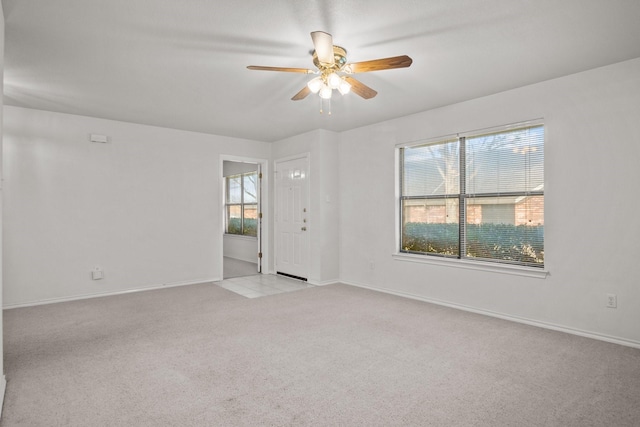 carpeted spare room featuring ceiling fan