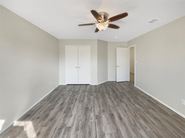 unfurnished bedroom with wood-type flooring, a closet, and ceiling fan