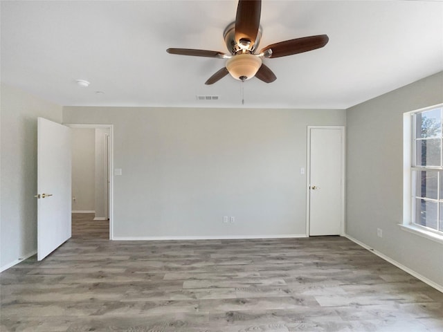 empty room featuring ceiling fan and light hardwood / wood-style floors