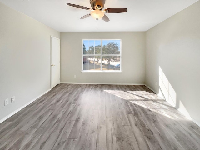 empty room with ceiling fan and light wood-type flooring