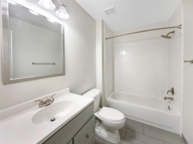 full bathroom featuring vanity, tiled shower / bath combo, and toilet