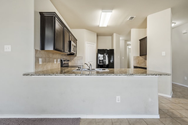 kitchen featuring dark brown cabinets, kitchen peninsula, and appliances with stainless steel finishes