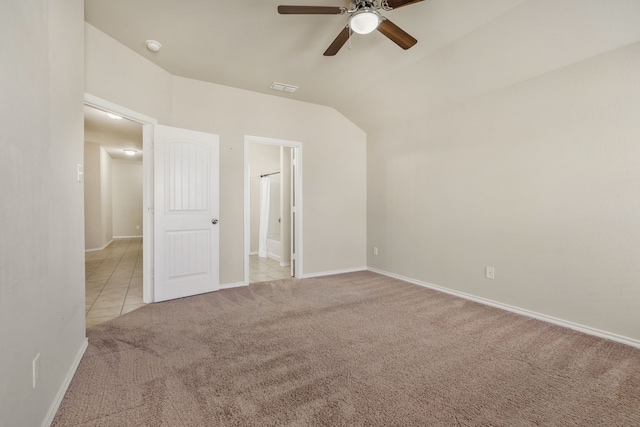 empty room featuring vaulted ceiling, light colored carpet, and ceiling fan