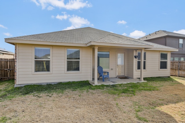 rear view of property featuring a patio area and a lawn