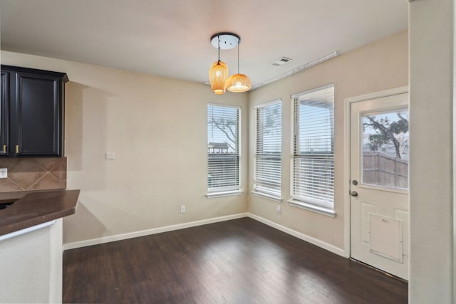 unfurnished dining area featuring dark hardwood / wood-style flooring