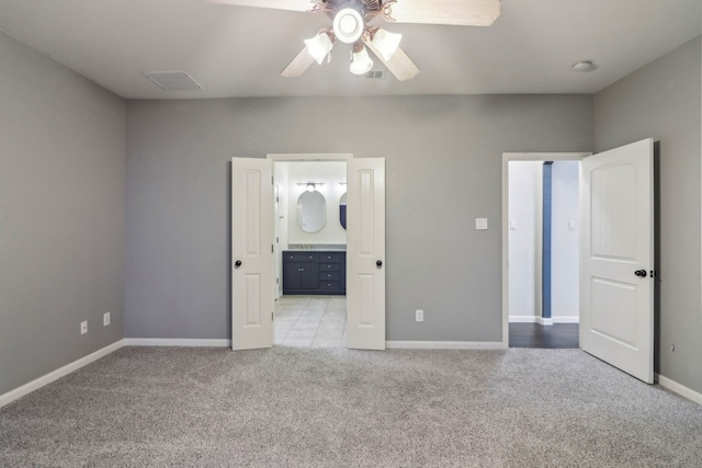 unfurnished bedroom with light carpet, ensuite bath, and ceiling fan