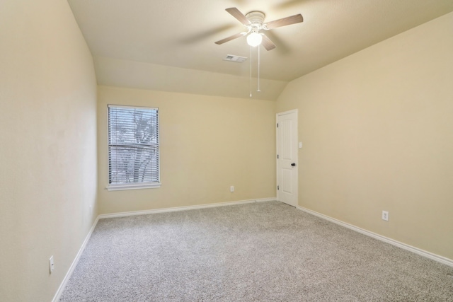 carpeted spare room featuring lofted ceiling and ceiling fan