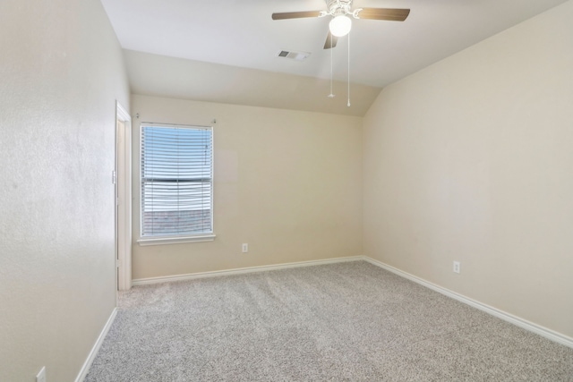 carpeted spare room with ceiling fan and vaulted ceiling