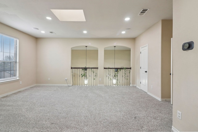 spare room featuring a skylight and carpet floors