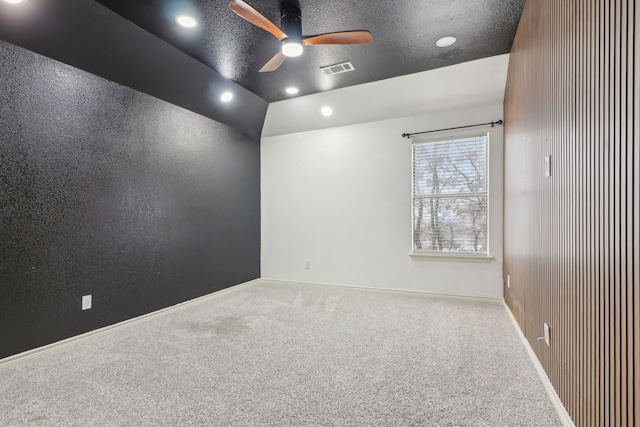 carpeted empty room featuring ceiling fan, lofted ceiling, and a textured ceiling