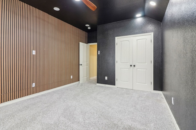 interior space featuring light carpet, vaulted ceiling, a closet, and ceiling fan