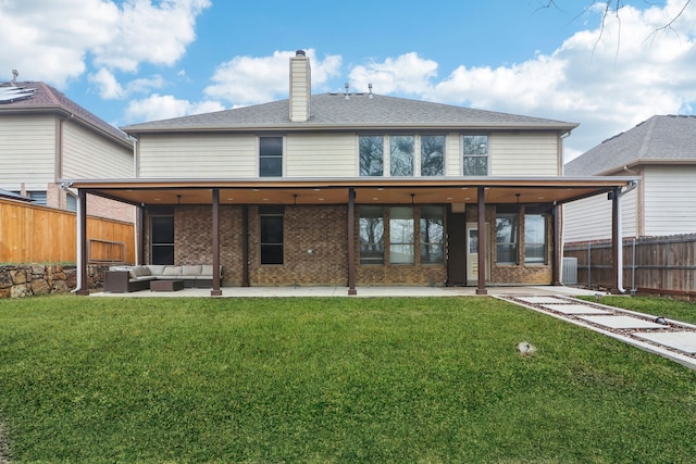 back of property with an outdoor living space, a patio, and a yard