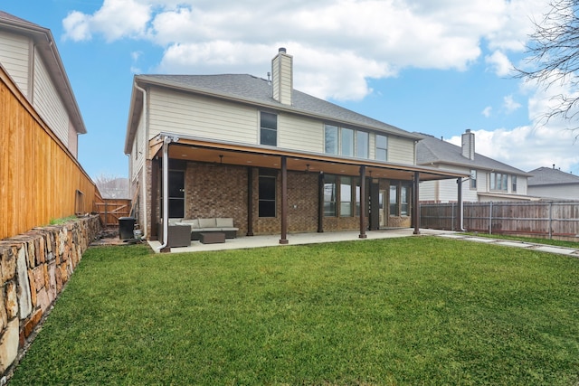 back of house featuring an outdoor living space, a patio area, and a lawn