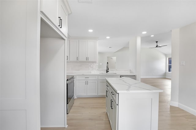 kitchen featuring light stone counters, appliances with stainless steel finishes, sink, and white cabinets