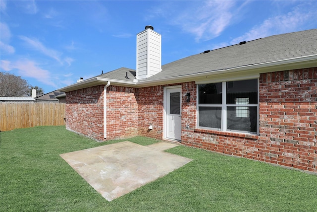 rear view of property with a yard and a patio area