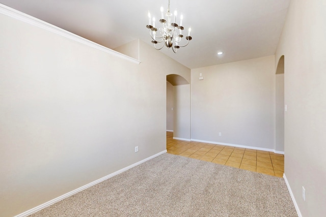 empty room featuring light carpet and a notable chandelier