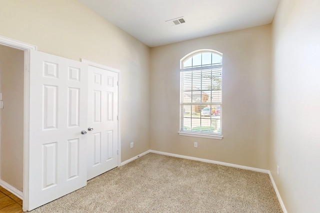 unfurnished bedroom with light colored carpet