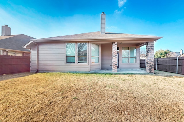 rear view of house with a yard and a patio area