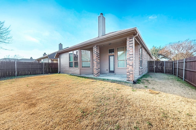 rear view of property featuring a yard and a patio area