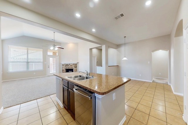 kitchen featuring sink, a center island with sink, dishwasher, pendant lighting, and a fireplace