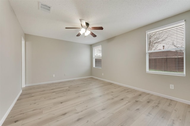 unfurnished room with ceiling fan, a textured ceiling, and light wood-type flooring