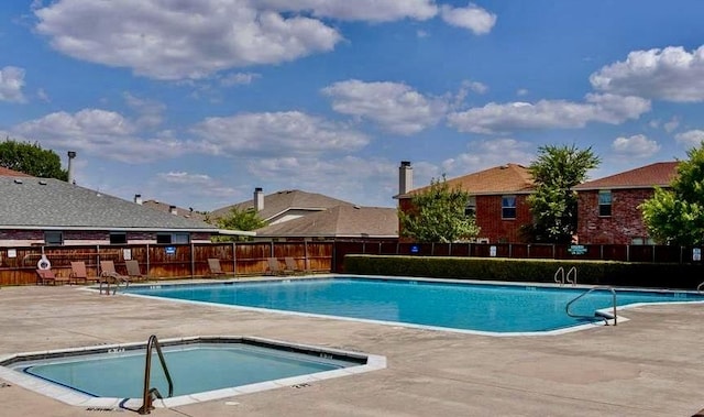 community pool with a community hot tub, a patio area, and fence