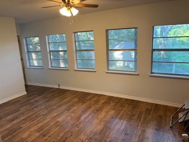 unfurnished room with dark hardwood / wood-style floors and ceiling fan