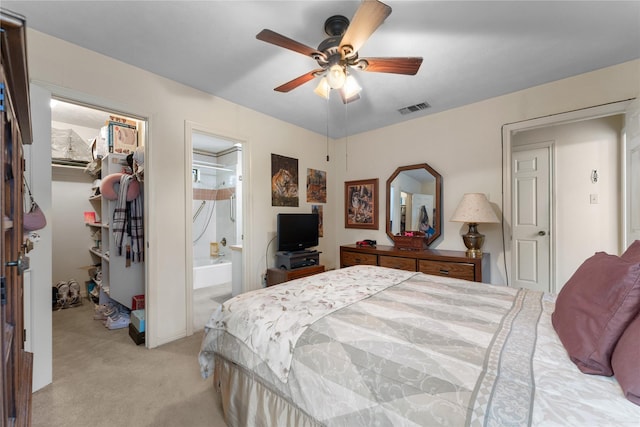 carpeted bedroom featuring a spacious closet, a closet, ceiling fan, and ensuite bathroom