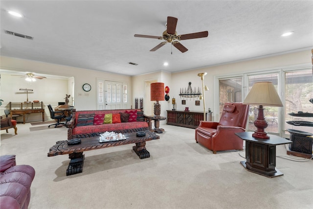 living room with plenty of natural light, light carpet, a textured ceiling, and ceiling fan