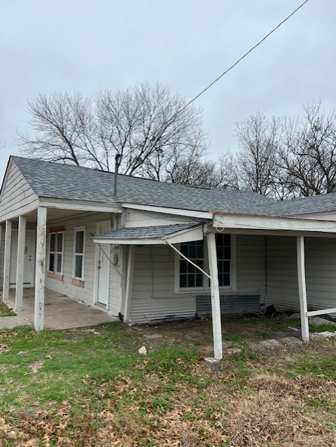 view of property exterior with a lawn and a carport